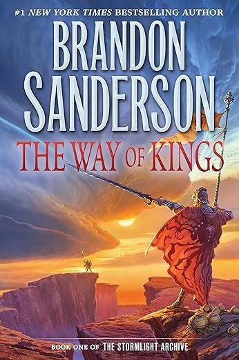 Fantasy book cover of 'The Way of Kings' by Brandon Sanderson shows an armored figure wielding a spear on rocky ground, under a dramatic, colorful sky.